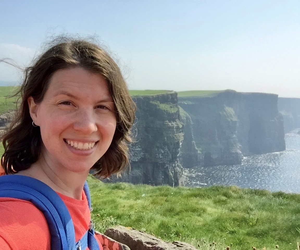 smiling female in front of the Cliffs of Moher
