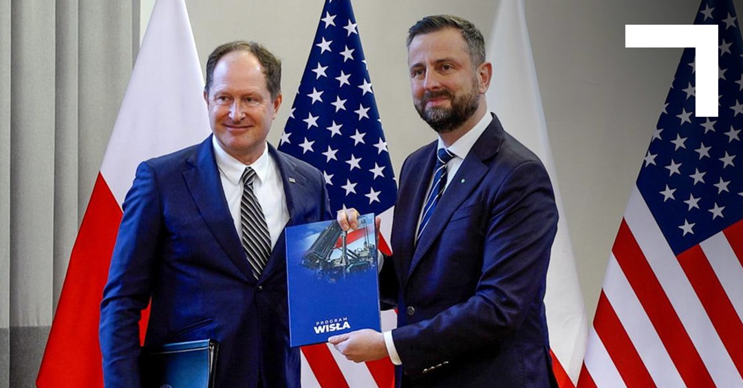two men with a U.S. and Polish flag behind them