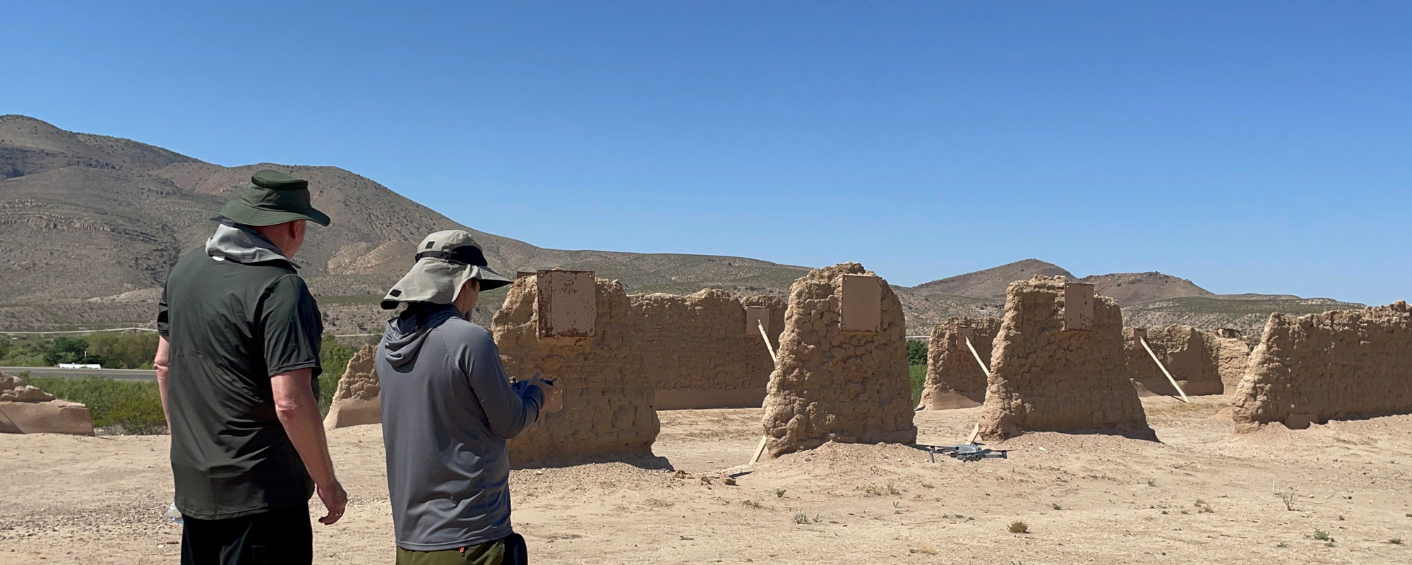 Two researchers prepping a drone for flight in New Mexico over cultural site. 