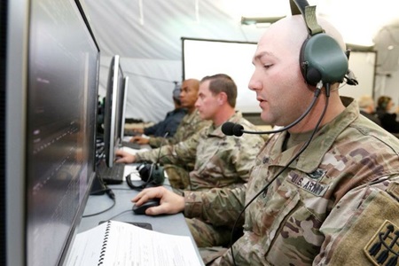 three US soldiers using the Integrated Battle Command System (IBCS) 