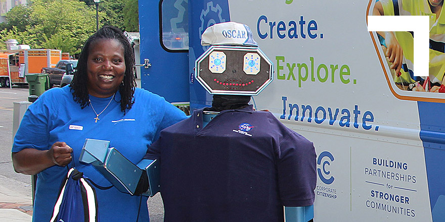 woman standing next to a robot.