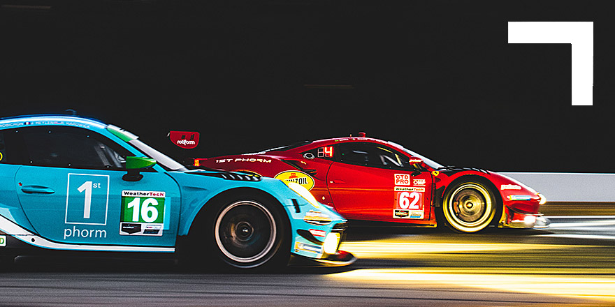 two race cars on track at night