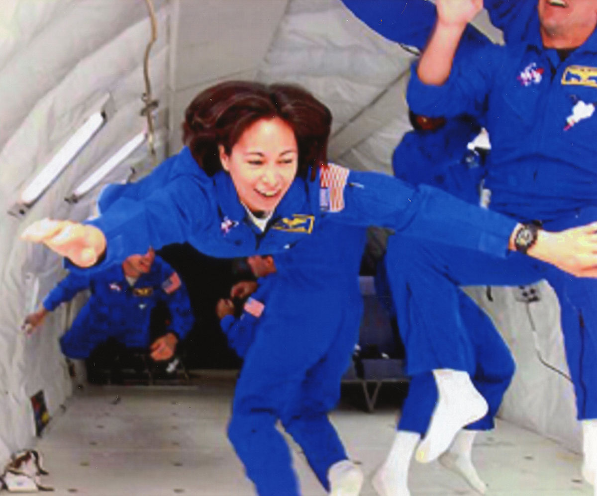 female astronaut in blue jumpsuit during weightless flight testing