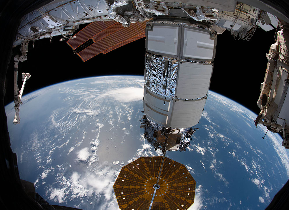 Cygnus spacecraft making delivery to the International Space Station above earth