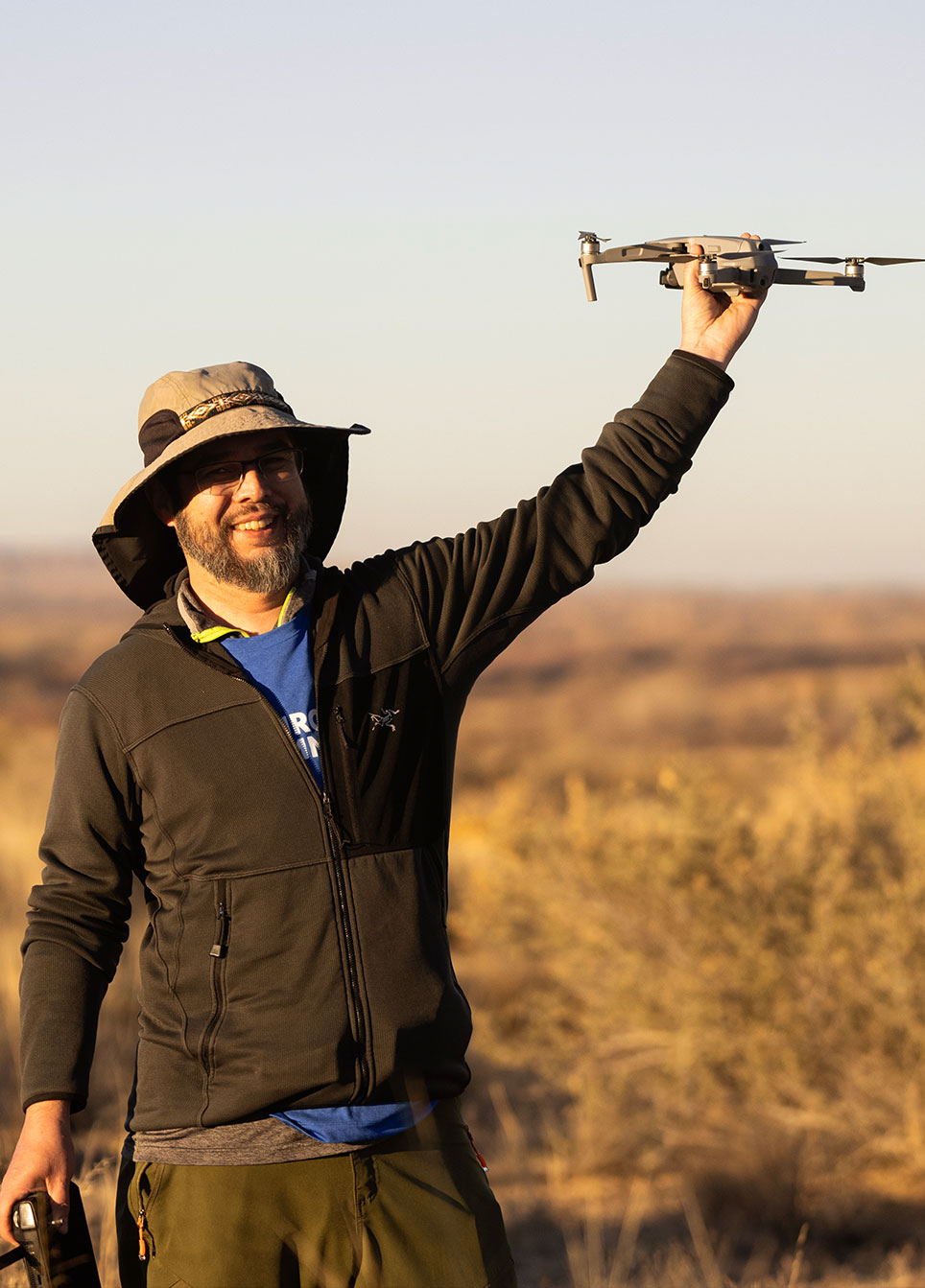 Man holds up drone in the desert of New Mexico. 