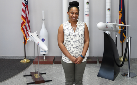 Black woman standing in front of rocket models