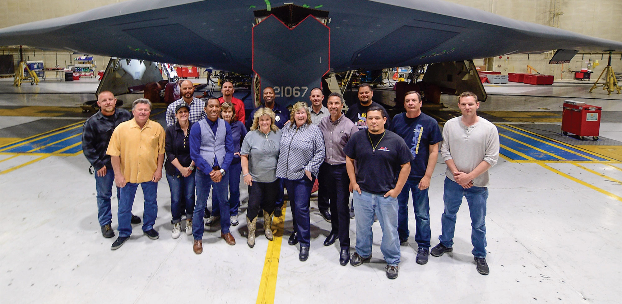 Group of employees standing in front of large aircraft.