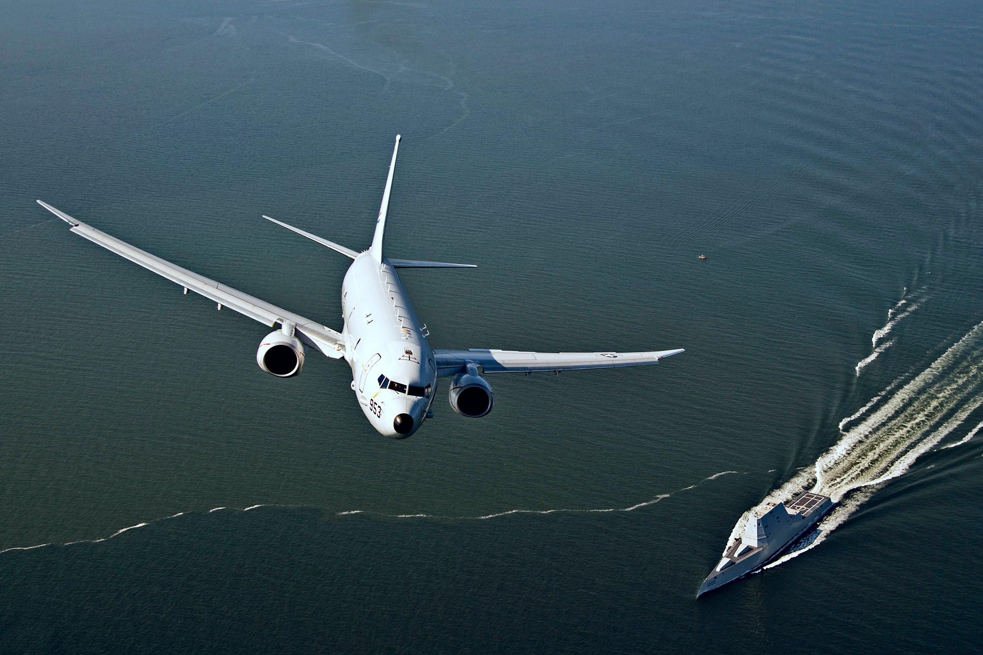 An aircraft flies over a boat in the Chesapeake Bay.