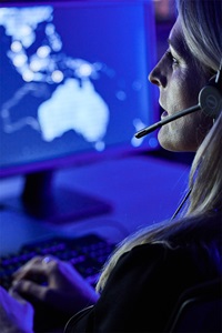 female with headset watching computer monitor