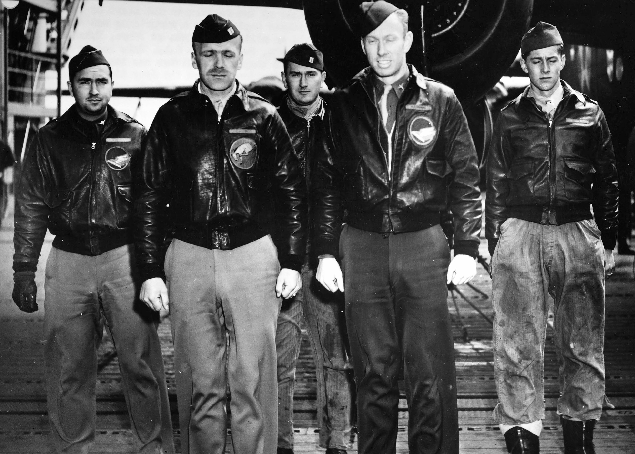 Five pilots standing in front of a plane for a group picture