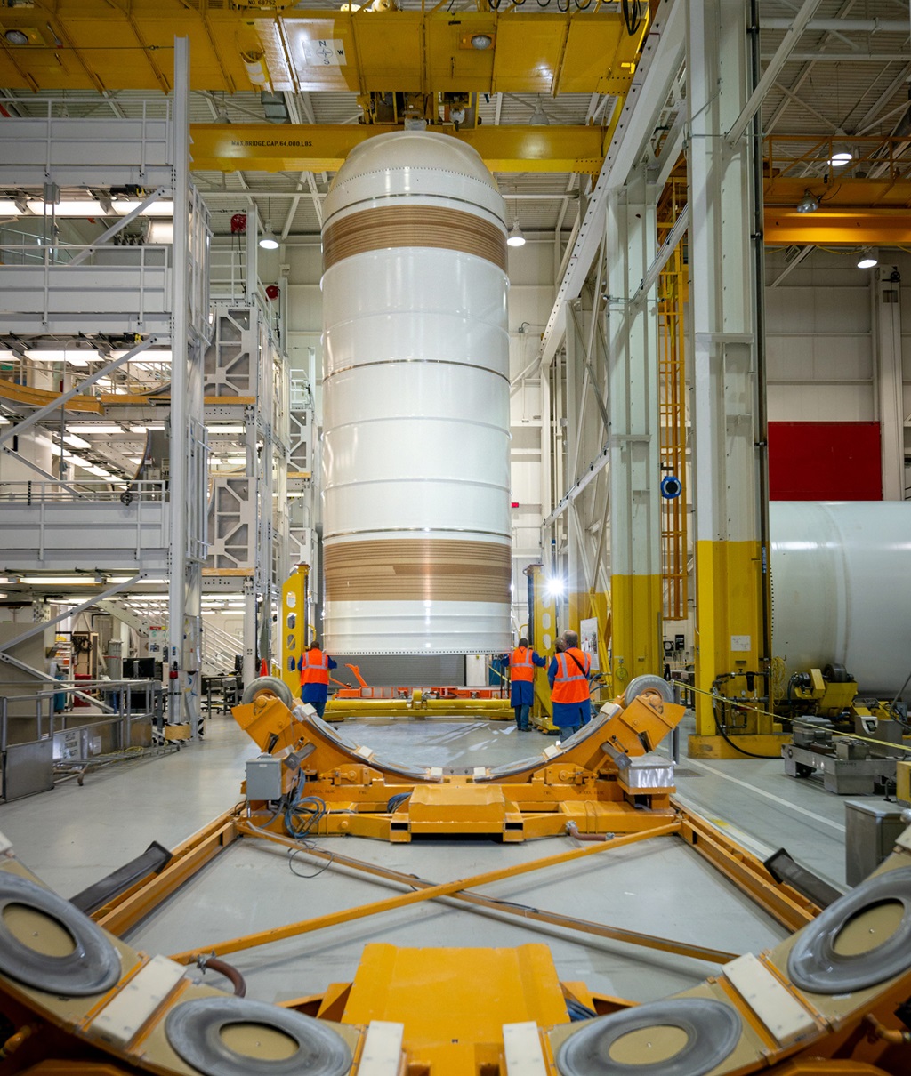 a solid rocket booster stands on end in a hangar