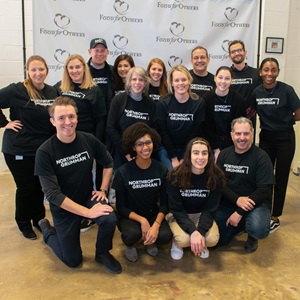 Employees volunteering at food bank wearing black t-shirts