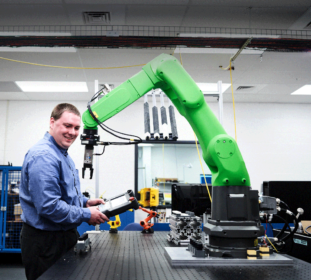 a man controls a robotic arm with a handheld controller