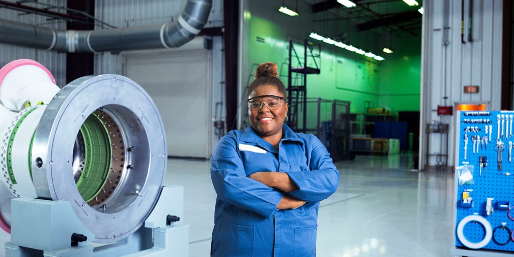 black female employee in blue jumpsuit in space facility