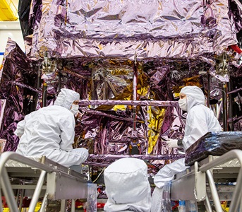 Three workers dressing spacecraft