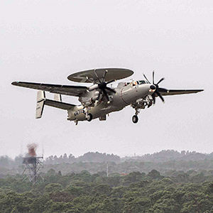 E-2D aircraft on takeoff over forrest