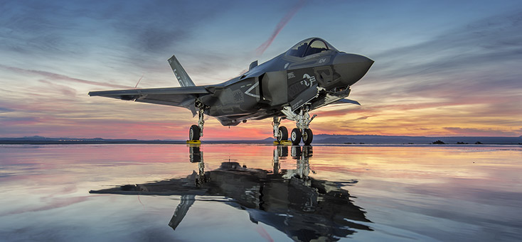 Standing, side-front view of an F-35 at sunset