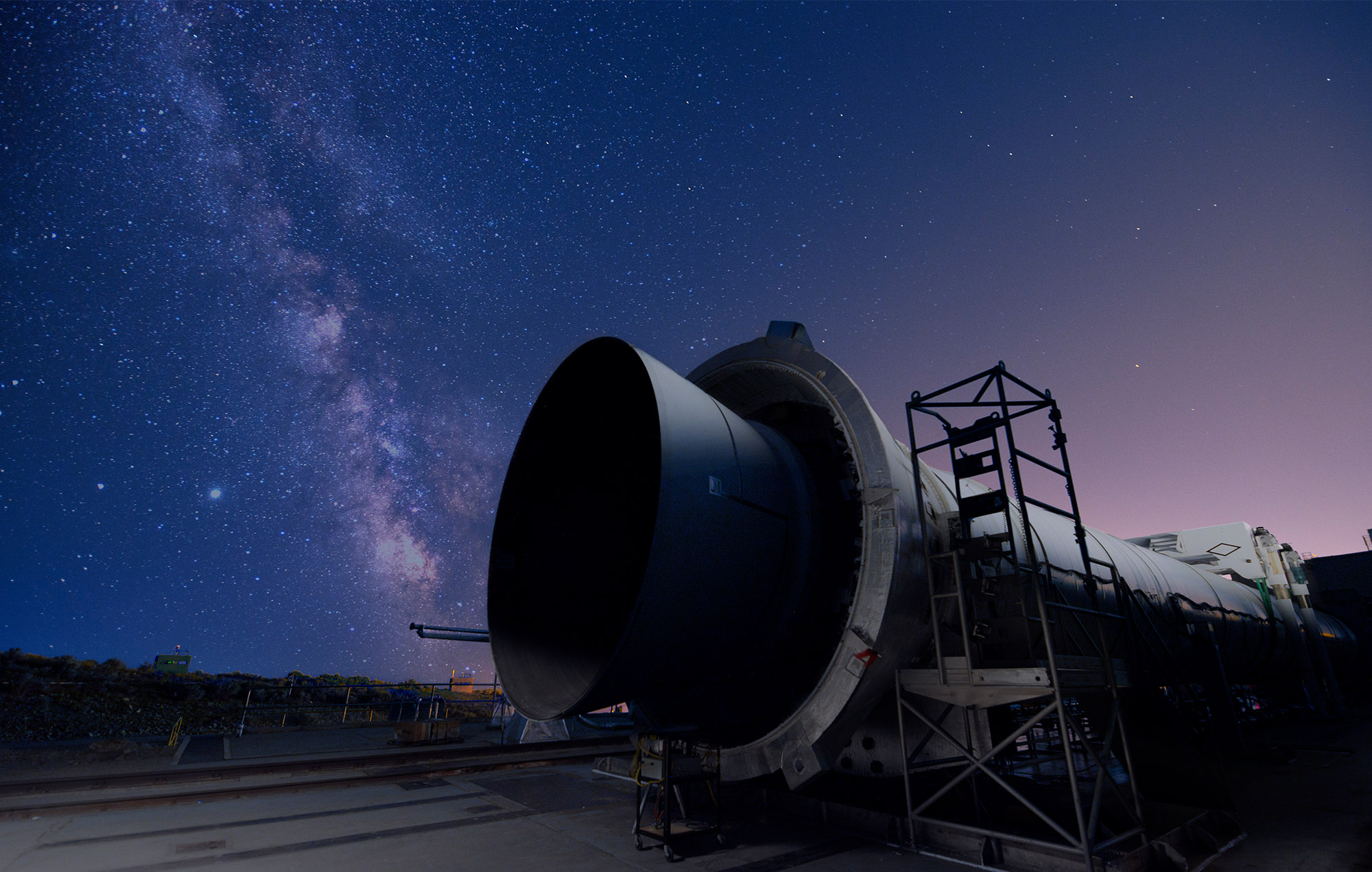 Twilit sky of a five segment rocket motor resting on platform under a star-filled sky