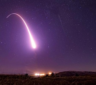 missile flying through the night sky giving off rocket trail