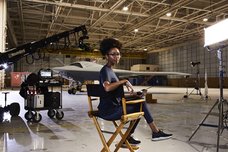 Female sitting in director style chair in hangar
