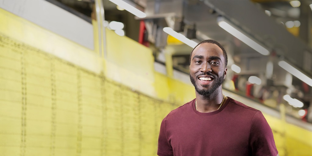 Smiling Black male in large warehouse