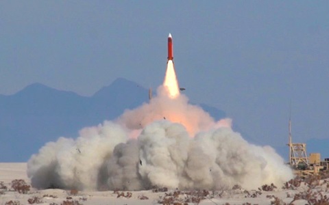 Missile launch in desert with mountains in background