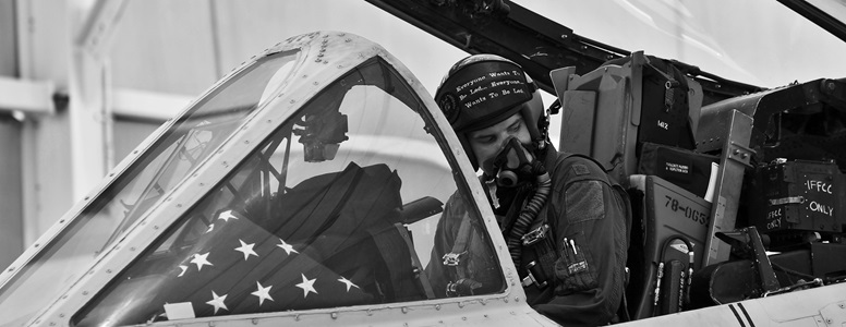 Black and white image of a pilot in an open cockpit
