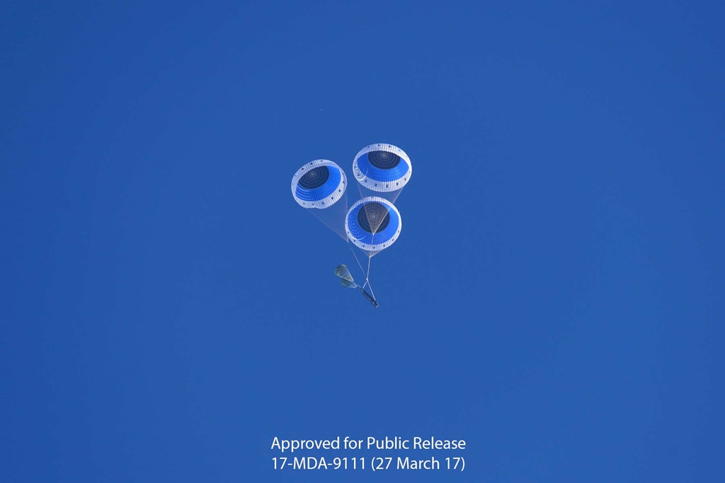 A launch vehicle descends from the sky in parachutes