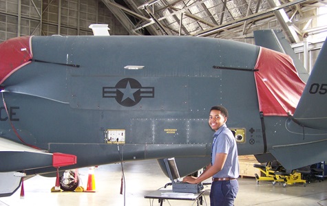 Young African American Male working on computer with Global Hawk in background