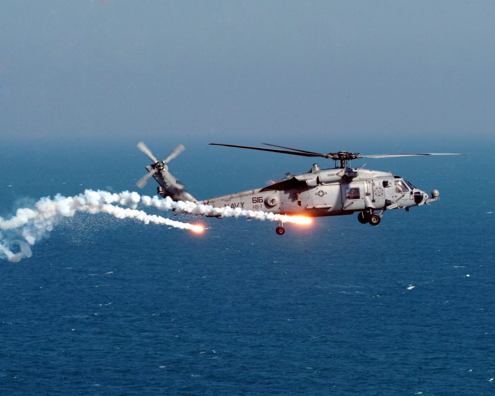 Navy helicopter dropping flares in the sky