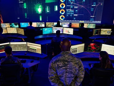Military personnel looking at multiple digital screens