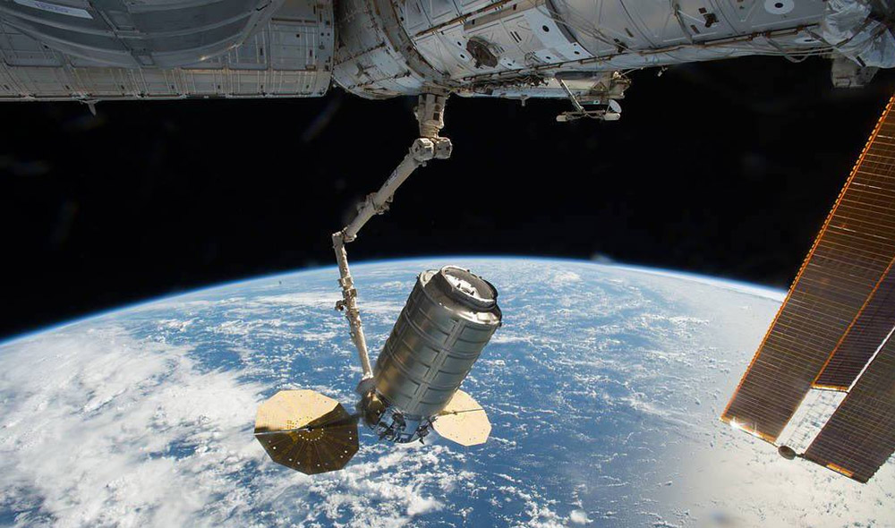 Cygnus equipment floating in space with earth in background
