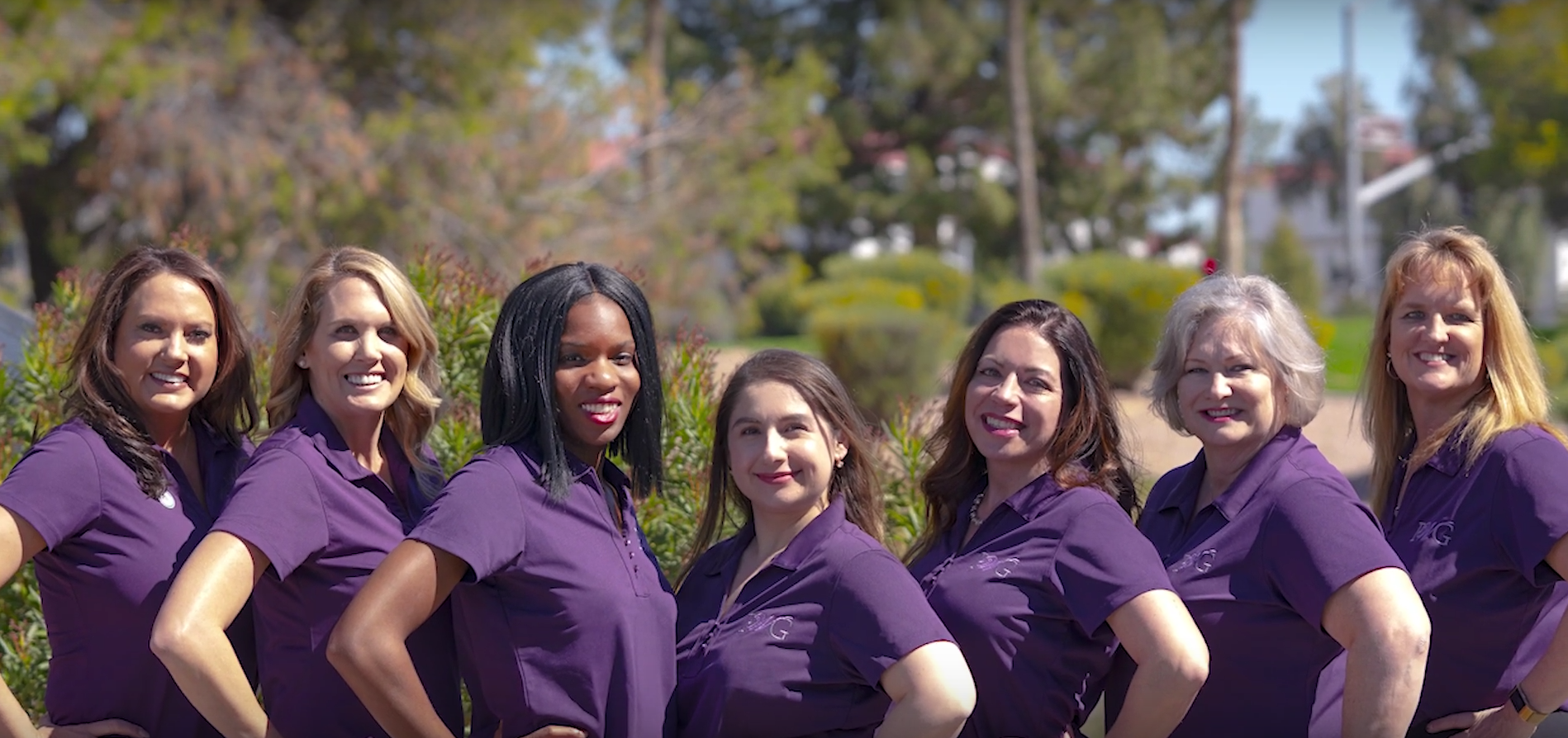 Women employees in purple shirts pose in celebration of International Women's Day