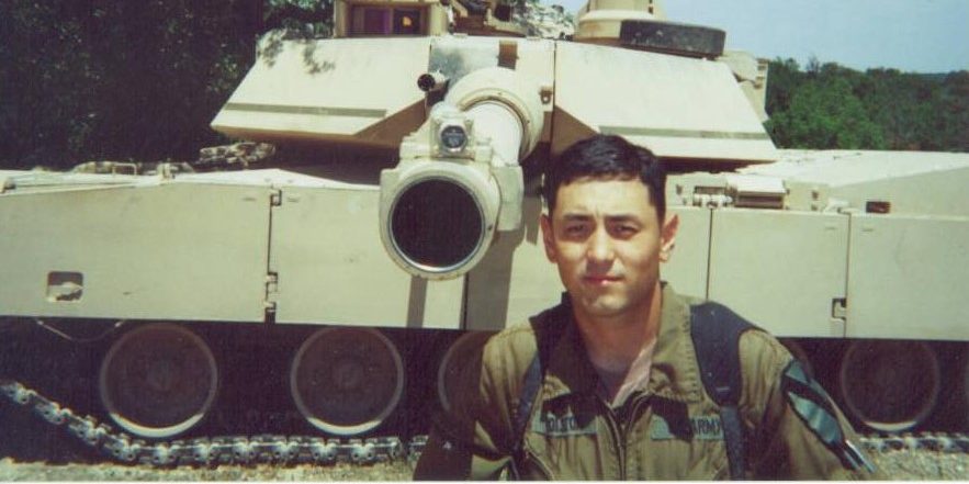 man standing in front of military tank