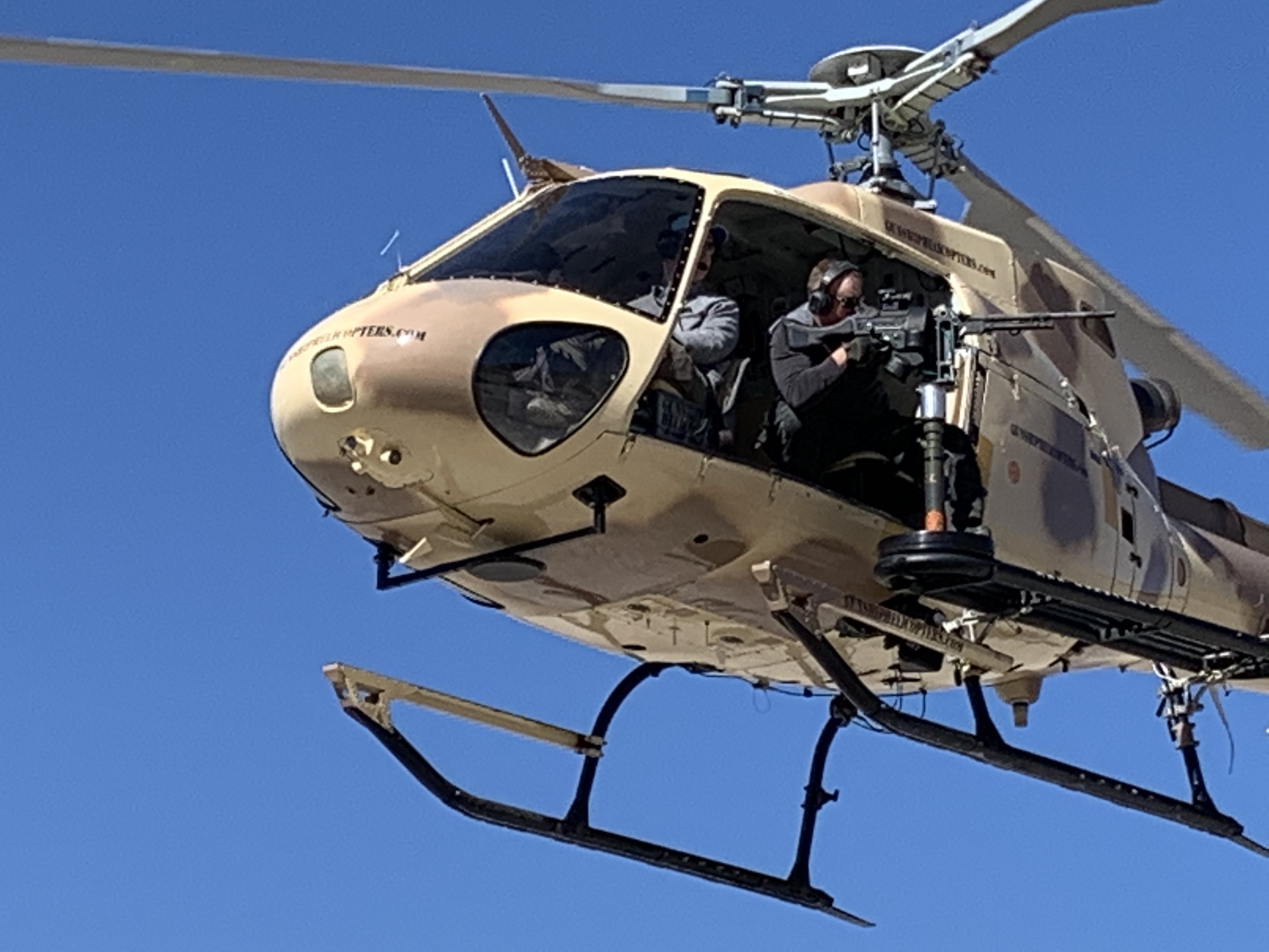 Man holding weapon in flying helicopter