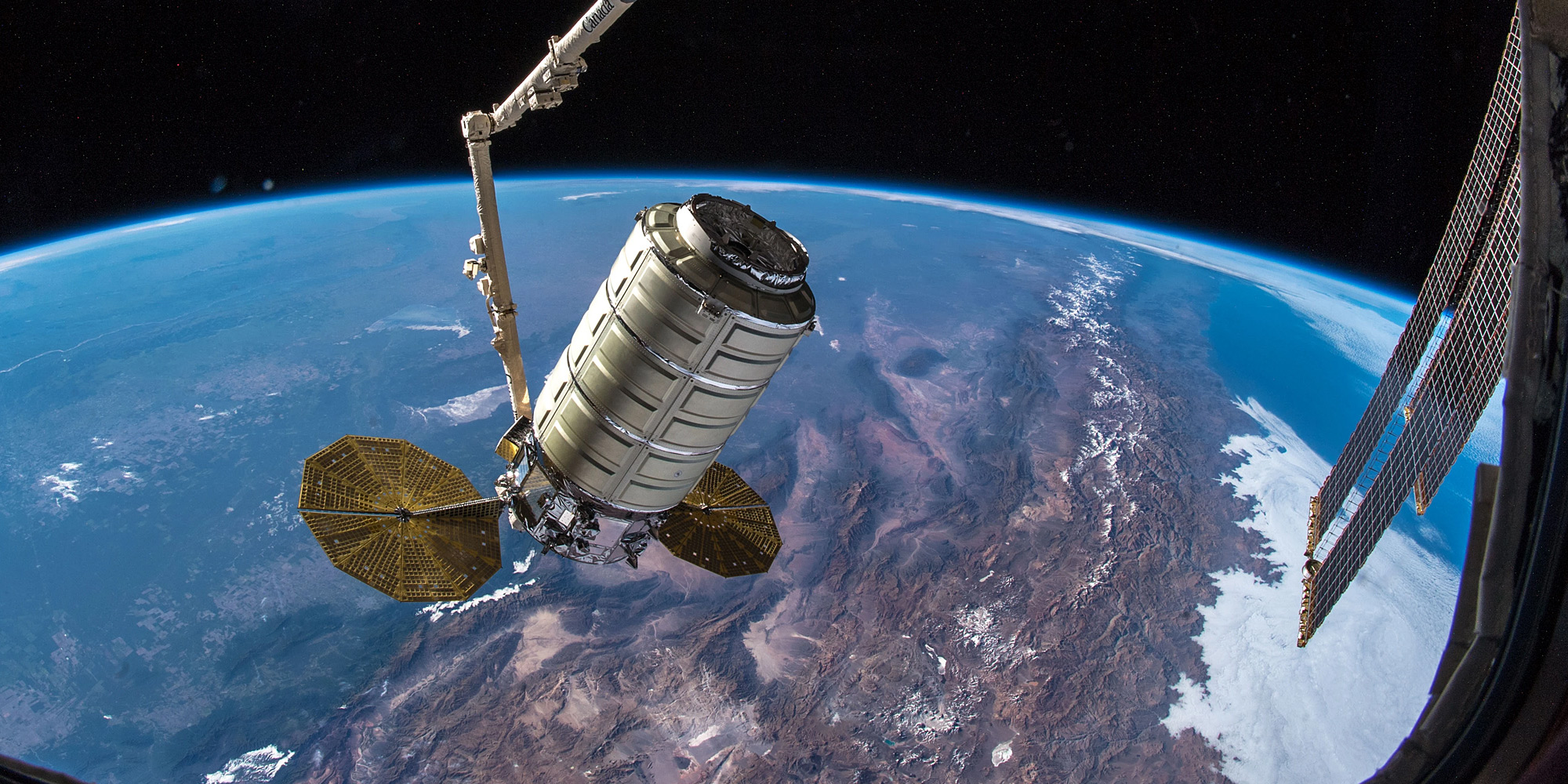 Cygnus spacecraft above earth docking with the International Space Station