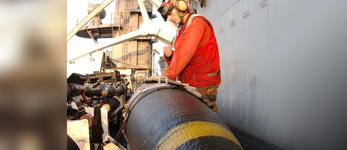 Navy sailor putting munition on an aircraft