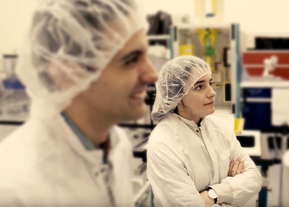 Male and female scientists in lab clothing.