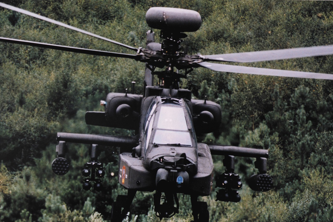 military helicopter in air with radar installed on top