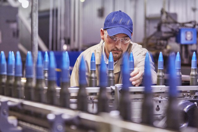 This is a man with a blue hat at an armament facility.