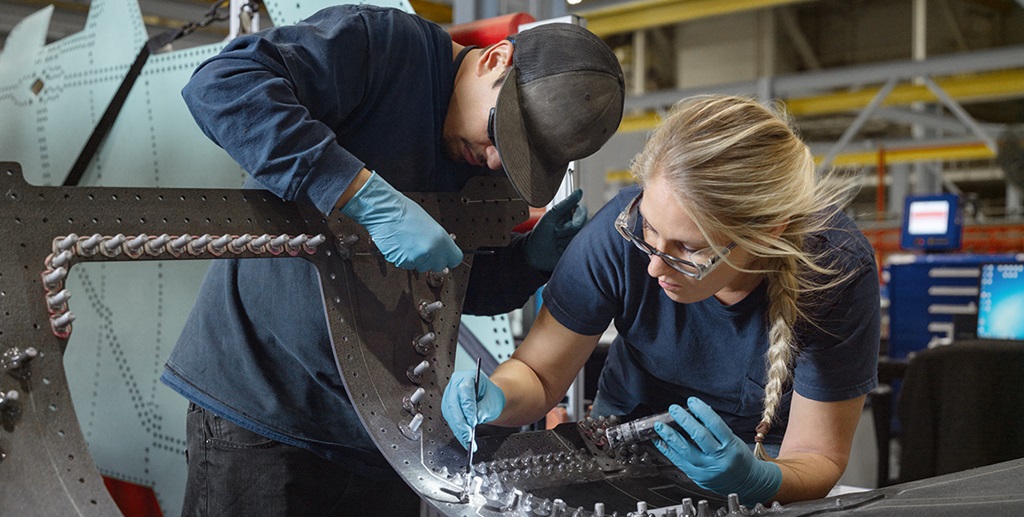 A man and a woman work together on a manufacturing project.