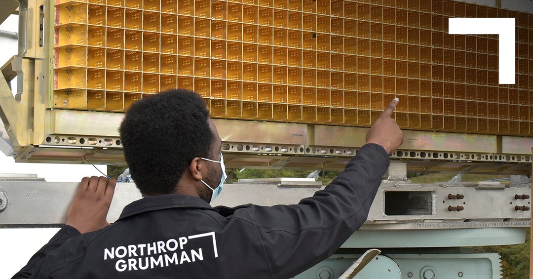 A man wearing a Northrop Grumman jacket points to a sensor panel