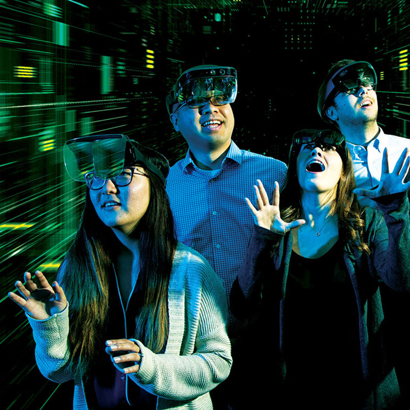 five people wearing VR goggles in dark room