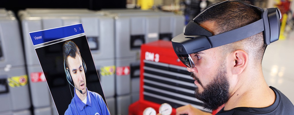 a man wears a XR headset to watch a video to work on machinery