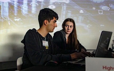 young man and woman in front of computer