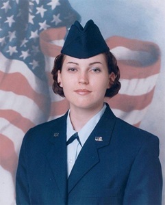 female soldier in uniform in front of flag
