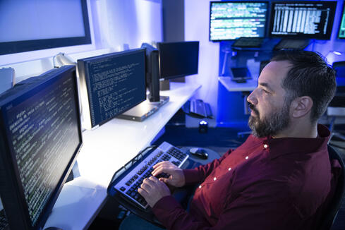Northrop Grumman employee standing in cyber room