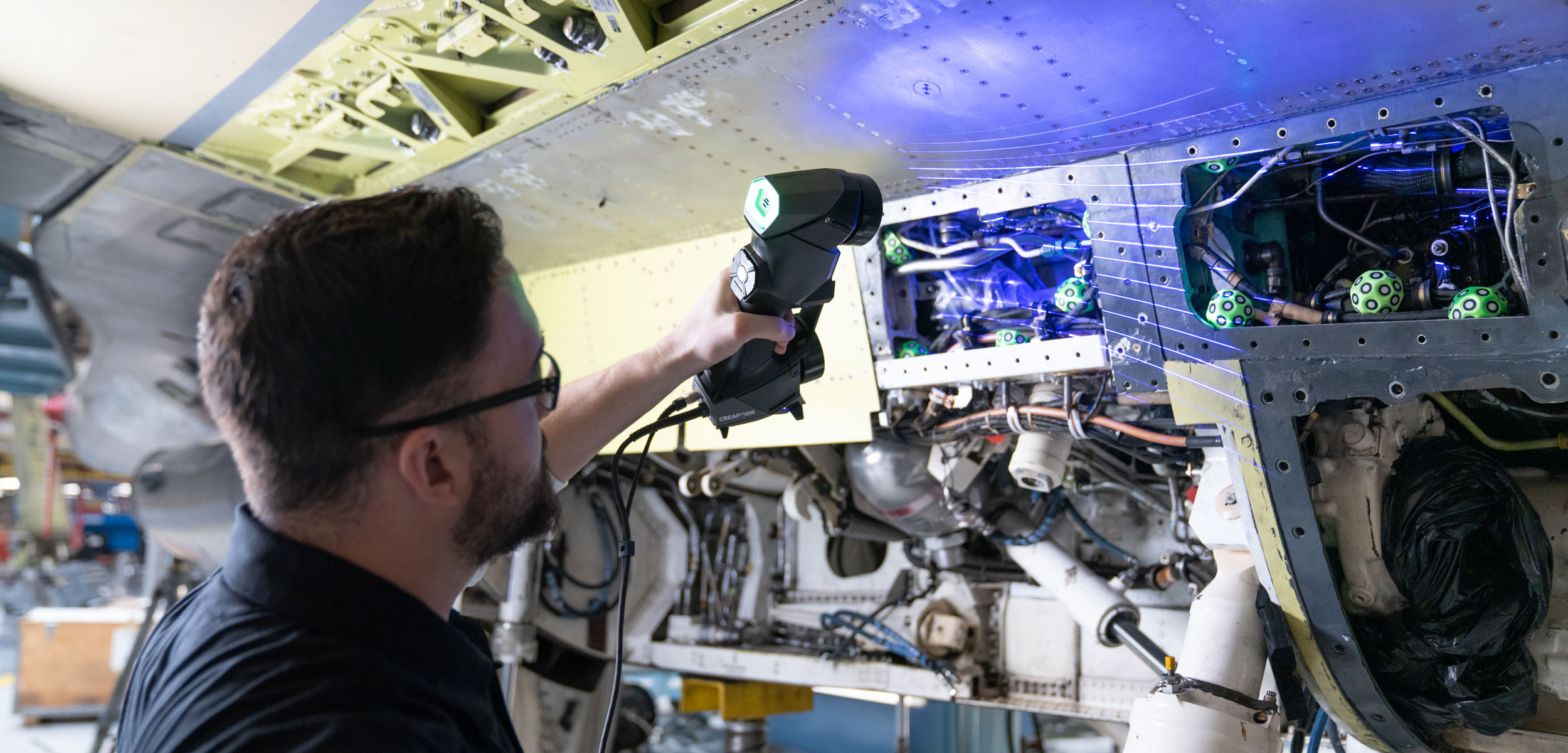 man with scanner repairing aircraft