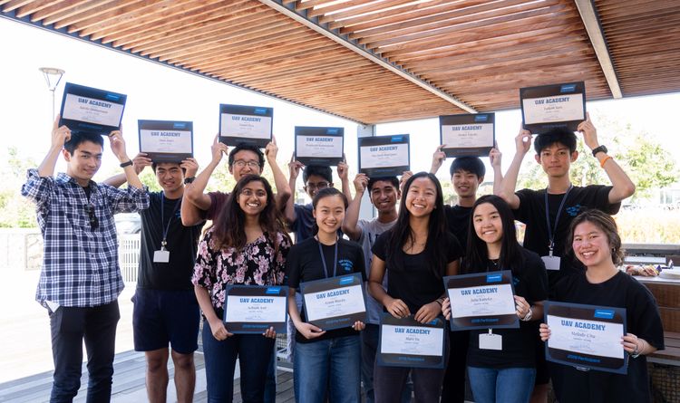 Young Asian students hold awards smiling