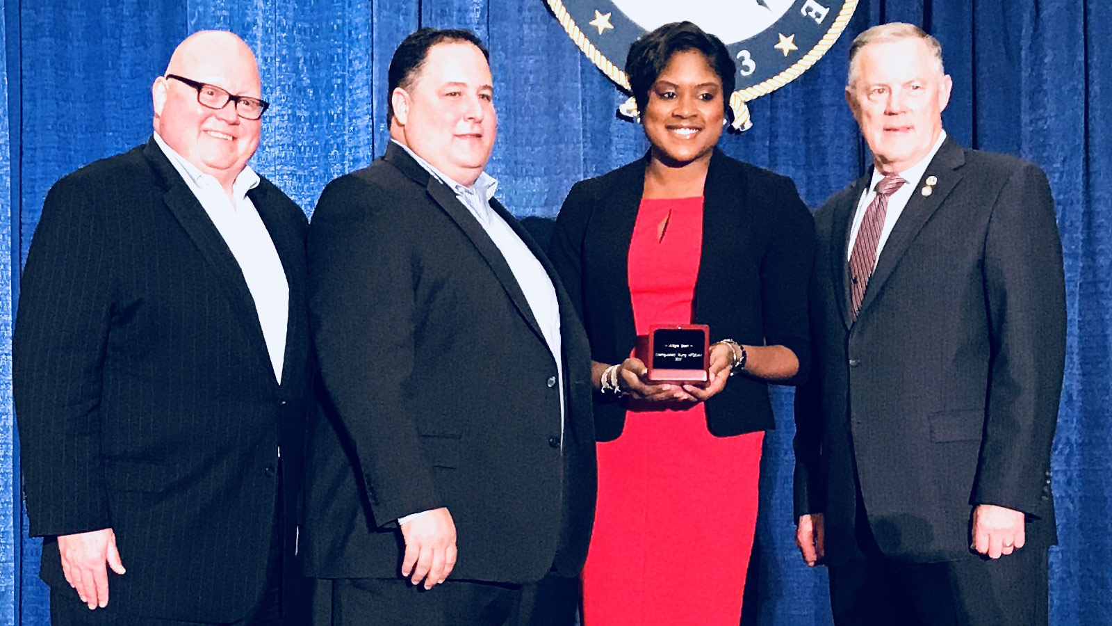 black woman with award standing with three men